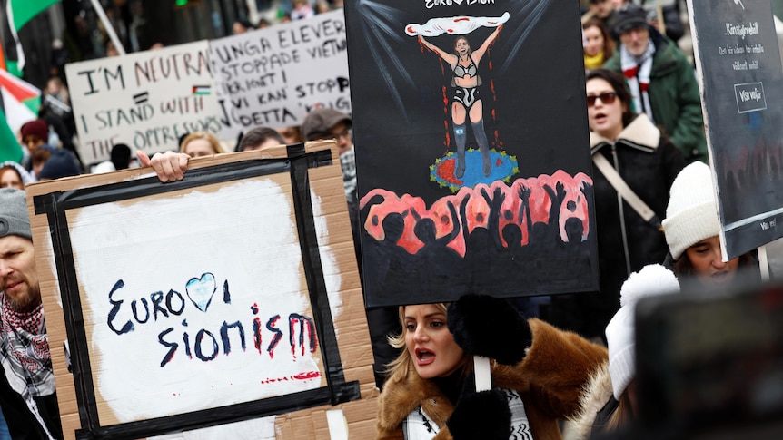 Protestors hold signs demanding a ceasefire in Gaza and Israel be excluded from the Eurovision Song Contest