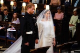 Britain's Prince Harry and Meghan Markle stand, prior to the start of their wedding ceremony.