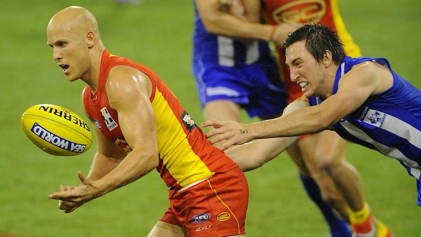 Gary Ablett handballs for the Suns during their match with the Kangaroos.