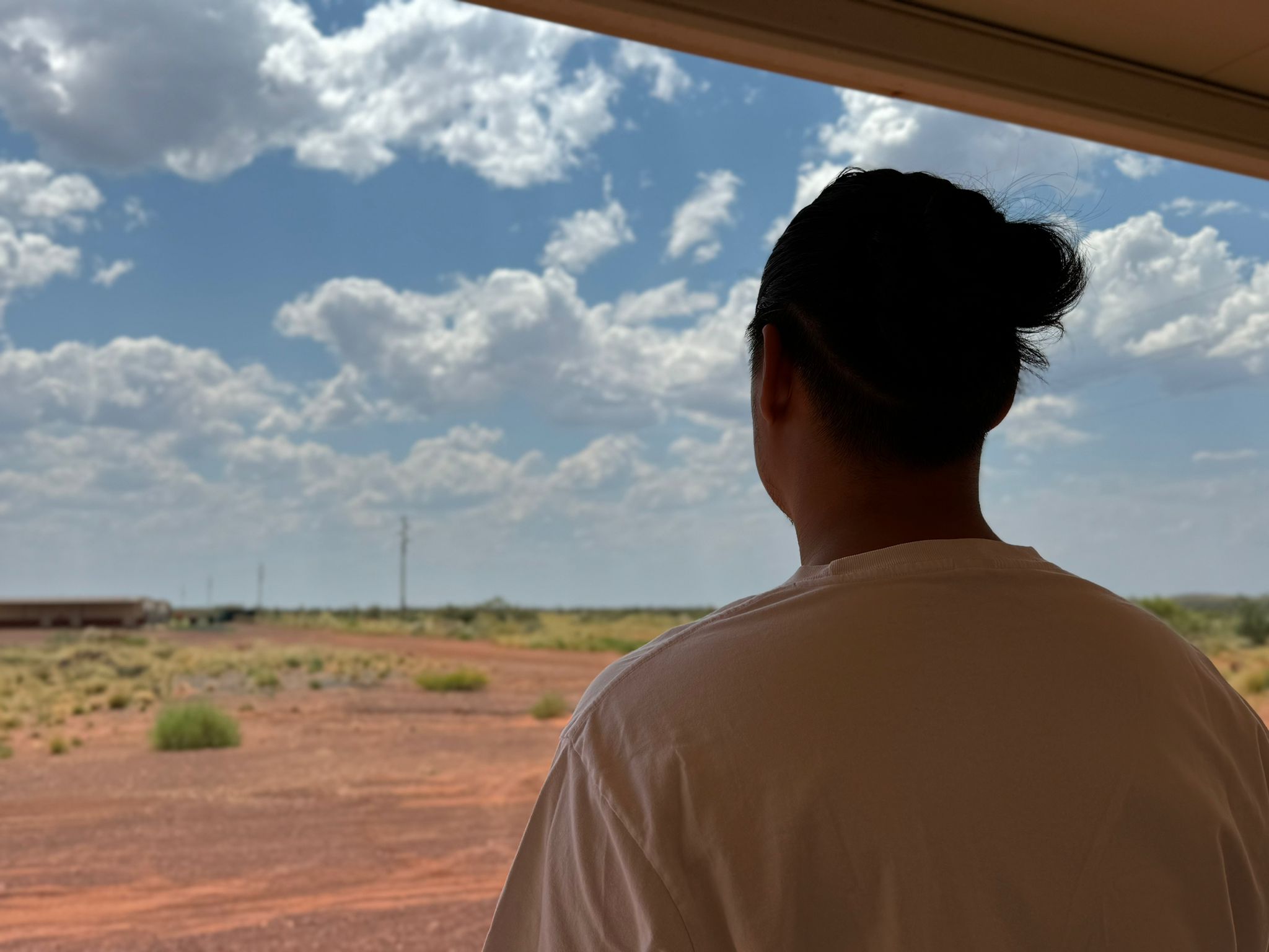 A man in bun pictured from behind.