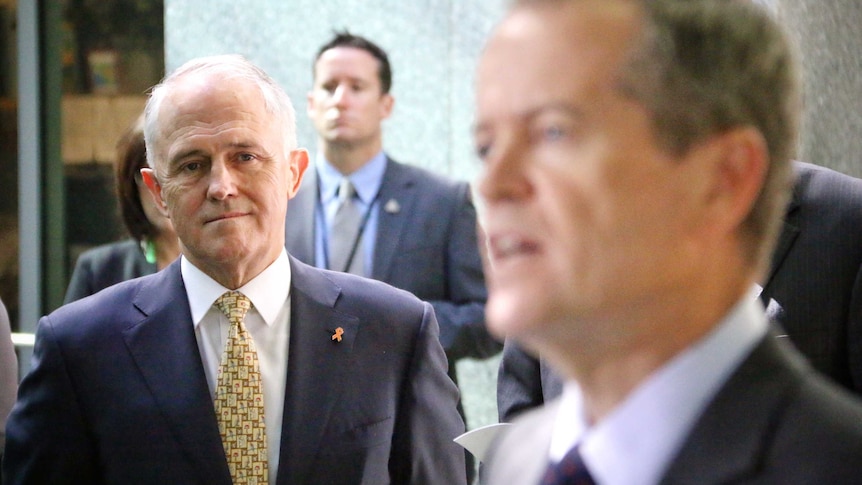 Prime Minister Malcolm Turnbull watches Opposition Leader Bill Shorten speak.