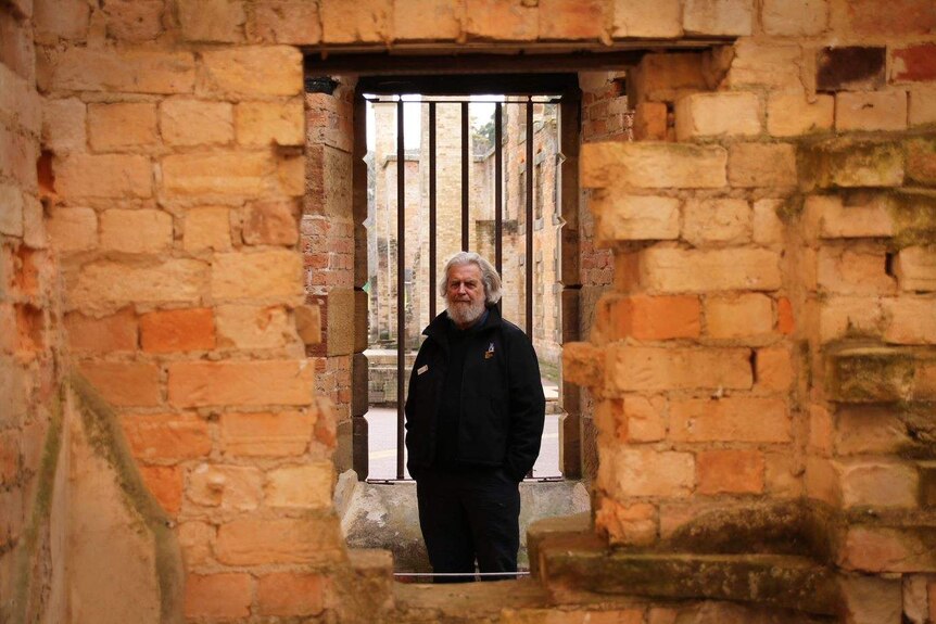 Archaeology Manager at Port Arthur Historic Site, David Roe looks through a window at the site.