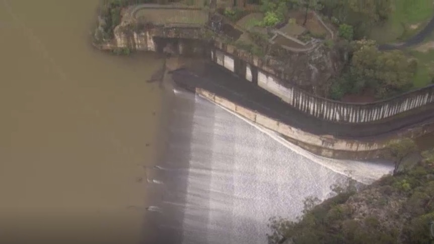 The dam releases a sheet of white flowing water