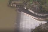 The dam releases a sheet of white flowing water