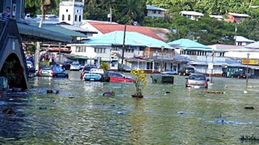 Water floods the street of a town in American Samoa in the wake of the tsunami