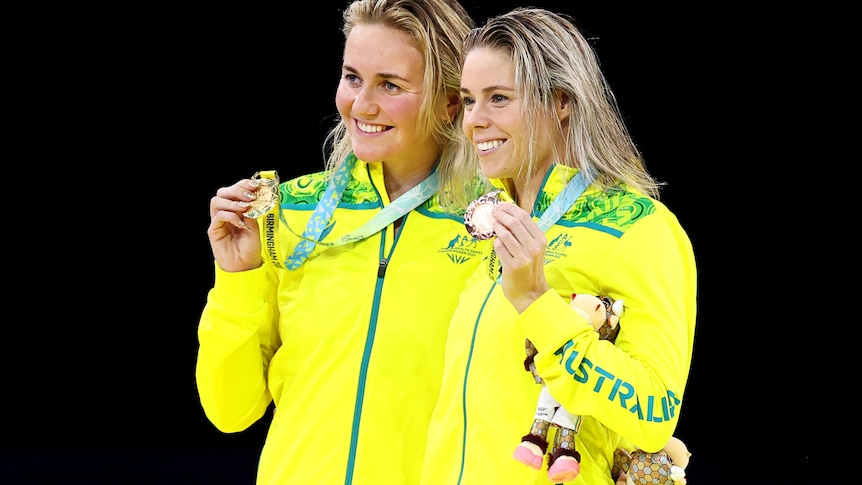 A gold and bronze medallist pose for photos after winning their event
