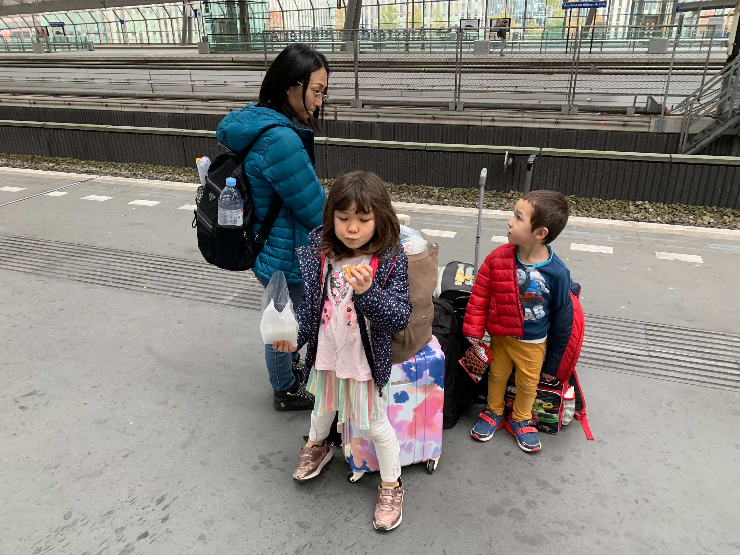 Junko, Juna and Remy waiting for a train in Amsterdam with their luggage.