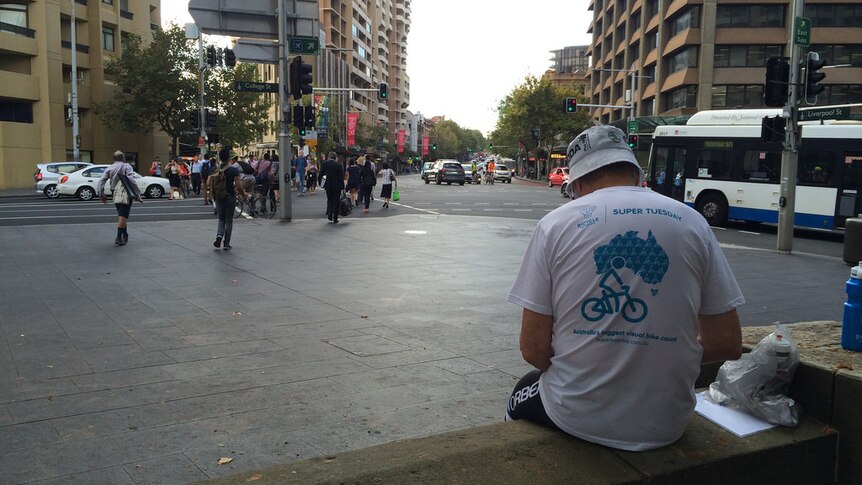 A man sits, keeping tally of passing cyclists.