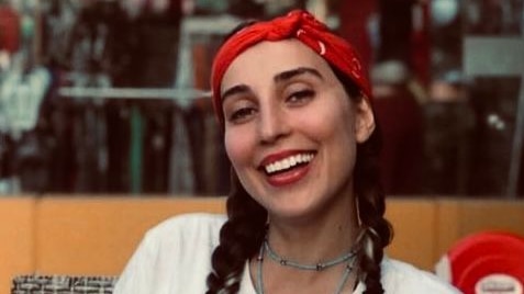 Elham wearing a red bandana smiling. 