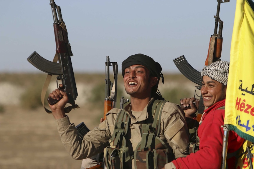 Fighters from the Democratic Forces of Syria carry their weapons.