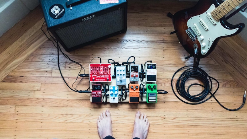 Looking down at a speaker with a Fender guitar to one side