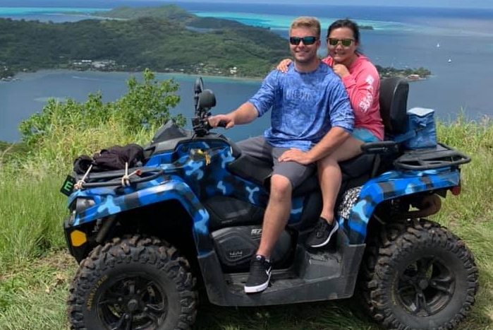 Jordan and Julia Erisman on a quad bike overlooking the coast.