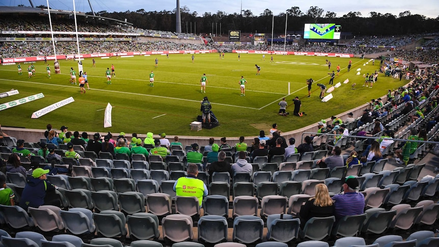 NRL fans can be seen looking at the action, with plenty of empty seats in the stands.