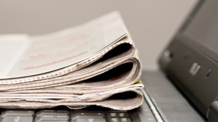 Newspaper sits on a laptop (iStockphoto)