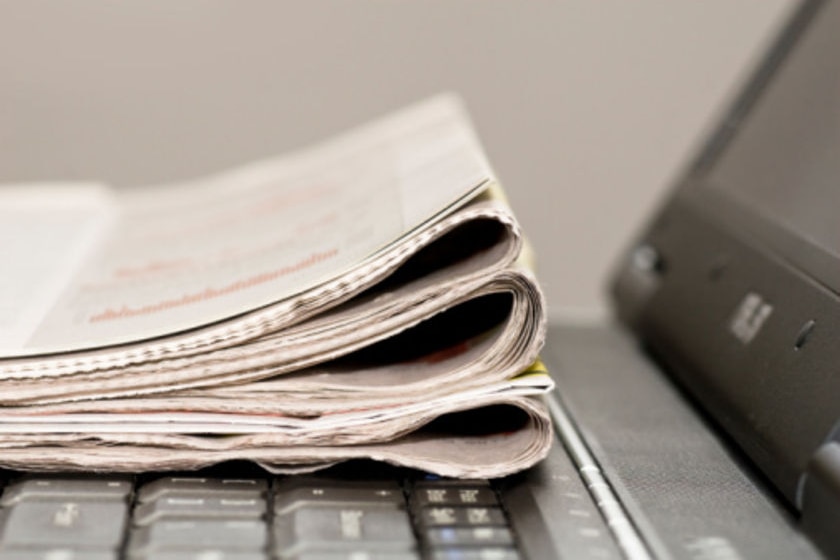 Newspaper sits on a laptop (iStockphoto)