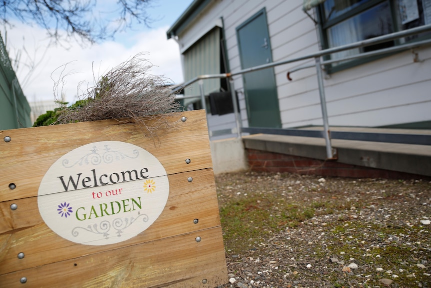 Sign on garden planter says "Welcome to our garden"