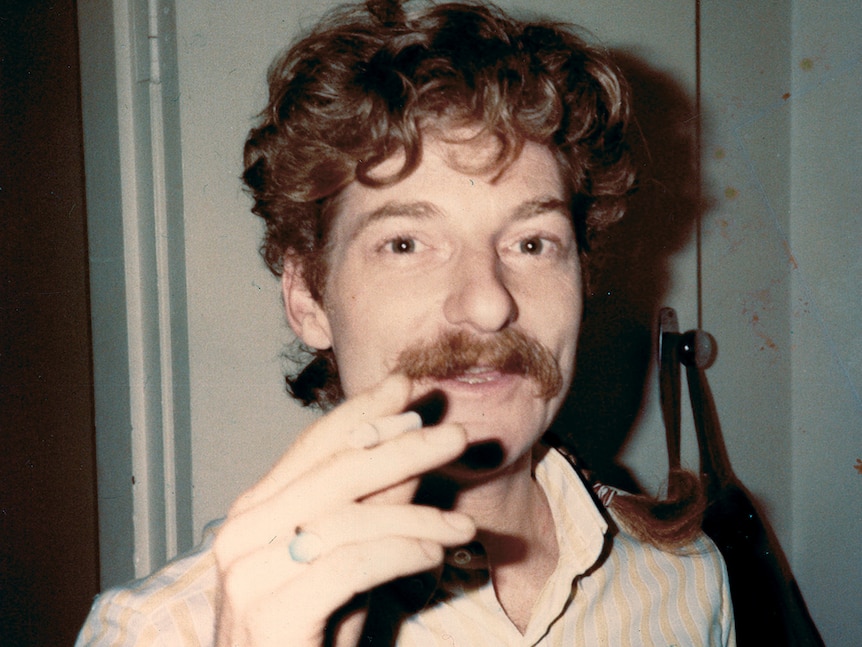 old colour photo of man smoking cigarette.