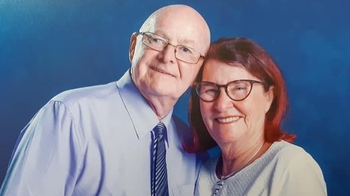 Studio portrait of couple with arms around each other