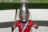 An unidentifiable Bayern Munich player wears the Champions League trophy on his head after the final against PSG.