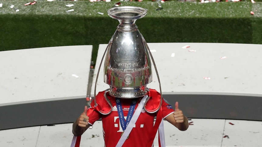 An unidentifiable Bayern Munich player wears the Champions League trophy on his head after the final against PSG.