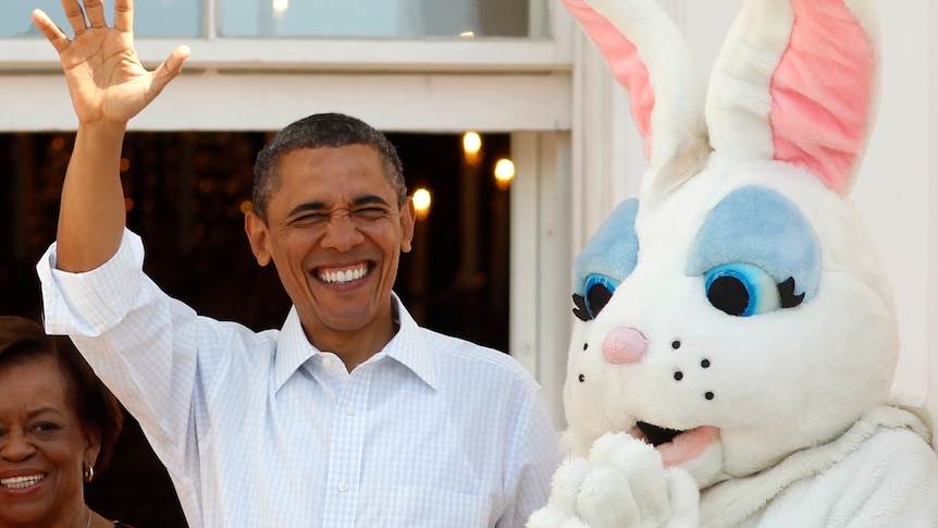 US president Barack Obama waves as he stands beside the Easter bunny during the 2012 White House Easter Egg Roll on the South Lawn in Washington on April 9, 2012.