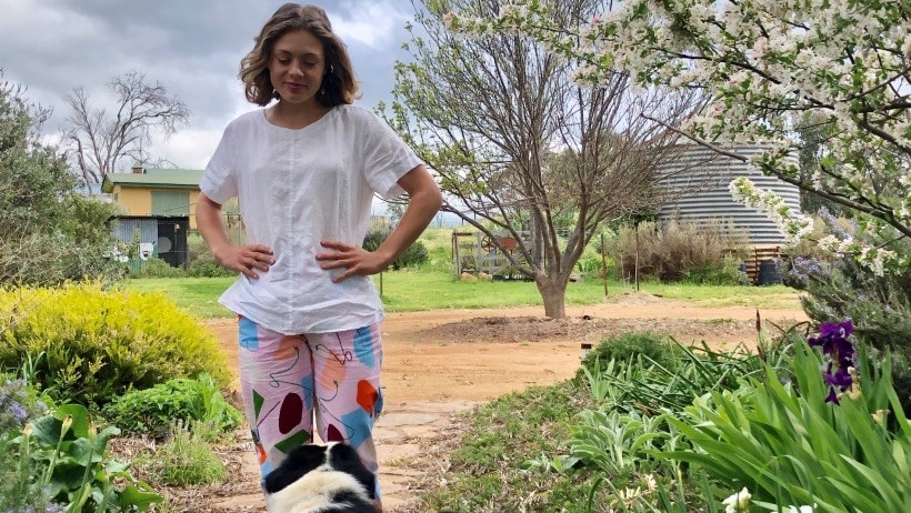 A girl looking at a black and white dog 