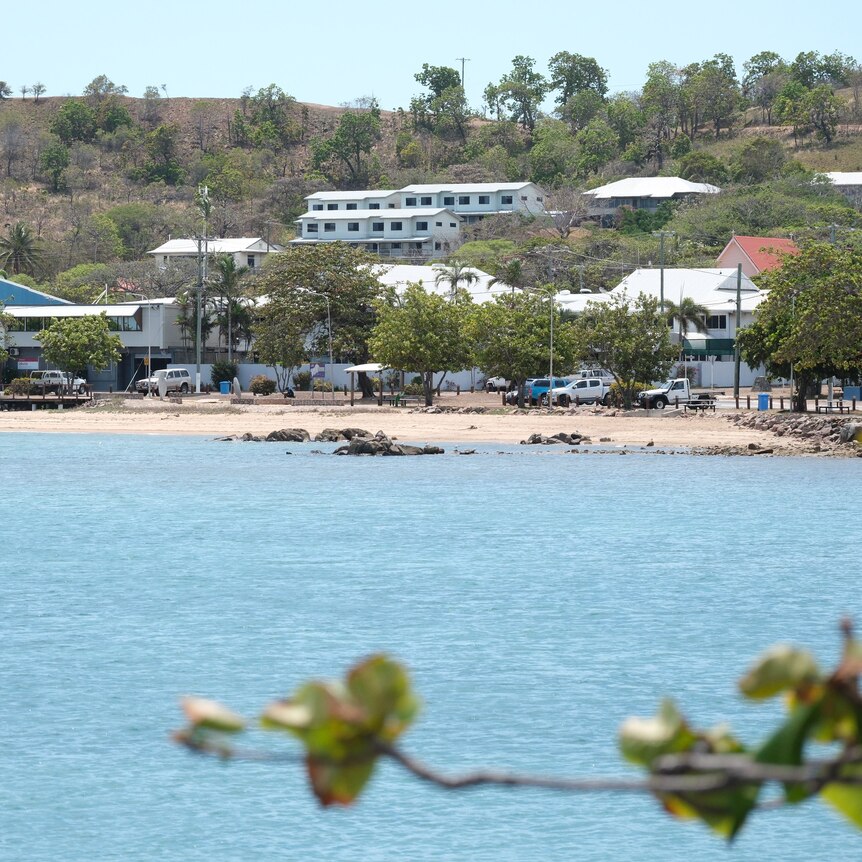 A view of a beach with buildings on the hill above