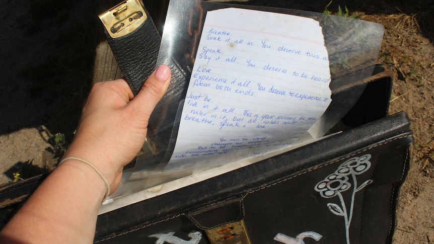 A photo of a briefcase containing laminated poetry written on paper