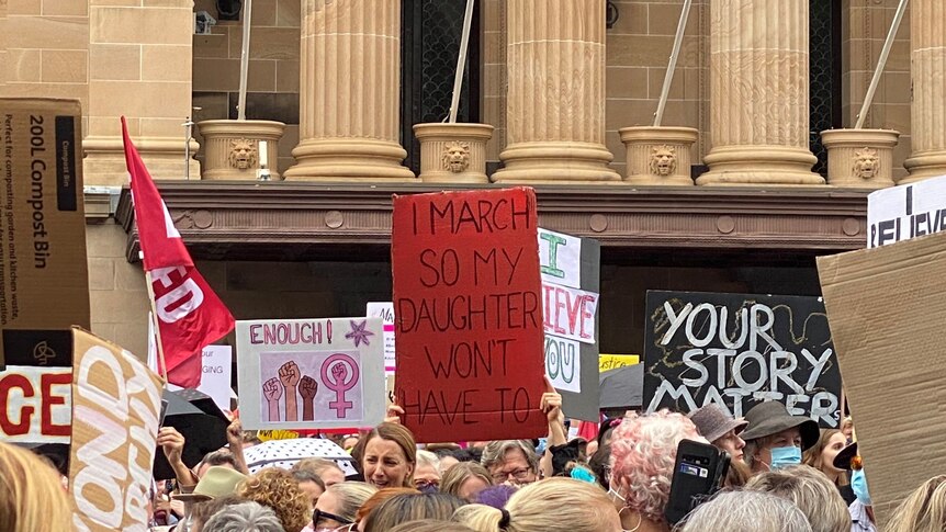 People holding up signs at the March for Justice in Brisbane.