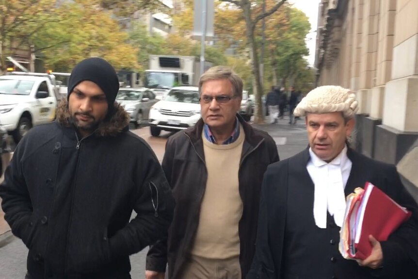 Mohamed Siddique (C) walks outside the Court of Appeal.