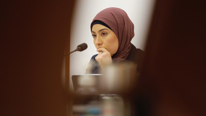 Senator Fatima Payman with hand on her mouth at Environment estimates committee