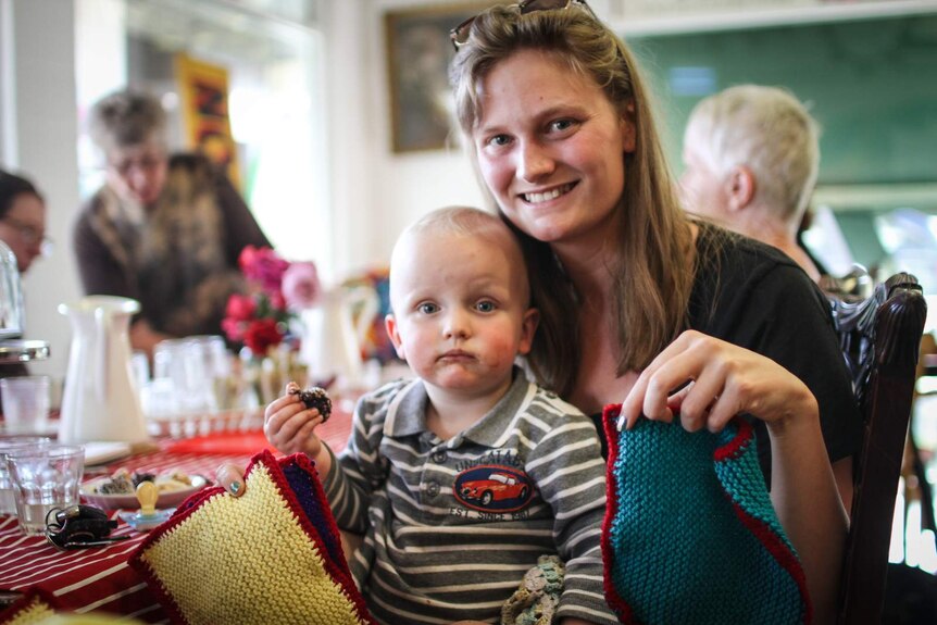Samantha and her son Patrick holding their knitted squares.