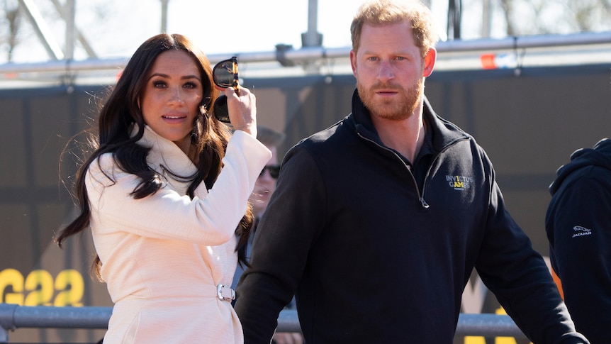 A couple walk together at a press event