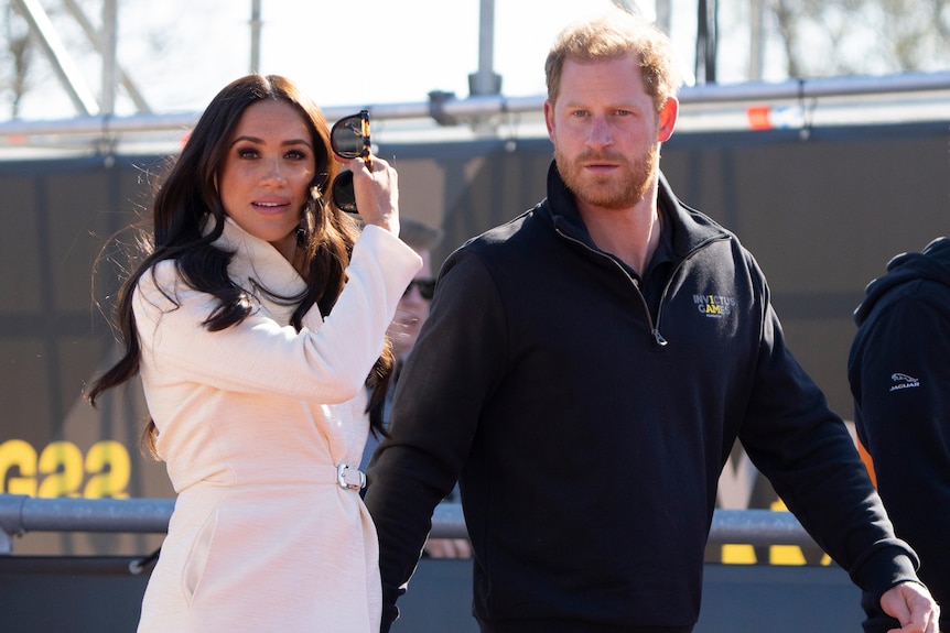 A couple walk together at a press event