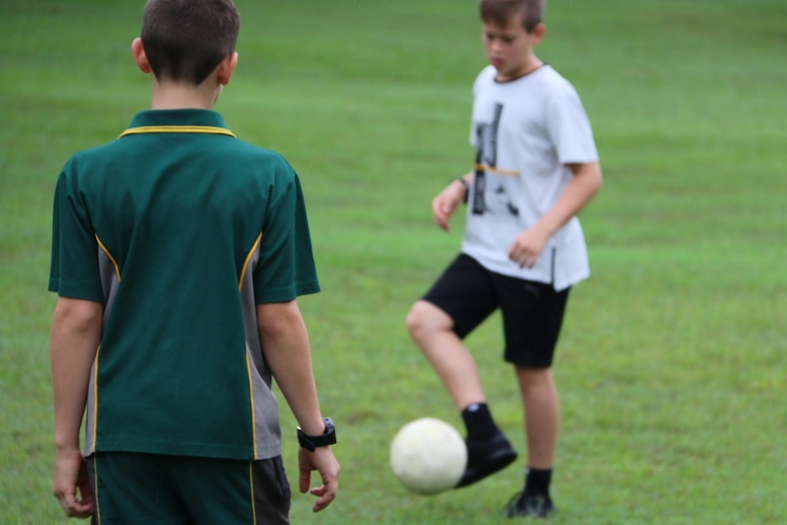 School children playing soccer while wearing the TicToc Track digital watch.