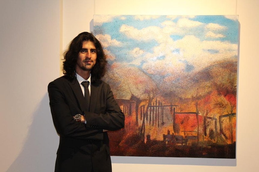 Mahdi Jahangirzadeh next to one of his artworks