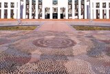 A huge dot-technique Indigenous artwork covers the paving in the forecourt of Parliament House.