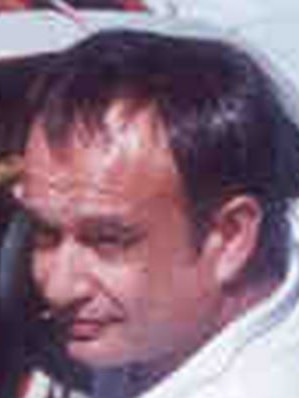 A grainy photograph of John Christianos, a man with short brown hair.