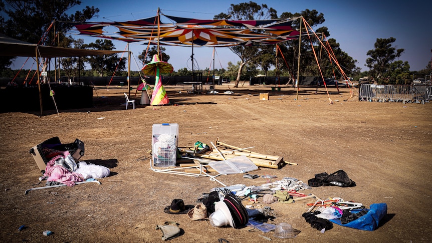 Hats and other objects left in a sandy field