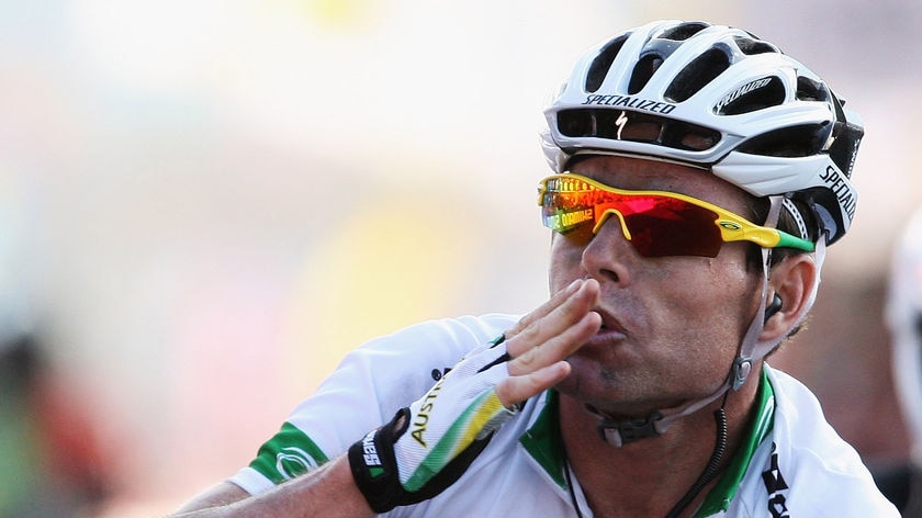 Cadel Evans waves as he crosses the finish line to win the men's road race