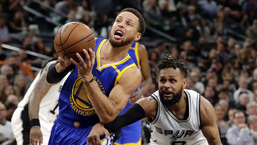 Steph Curry (L) drives past Patty Mills on his way to the basket in Game 4 in San Antonio.