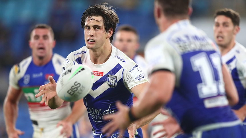 A Canterbury Bulldogs NRL player passes to his left during a match against Newcastle.
