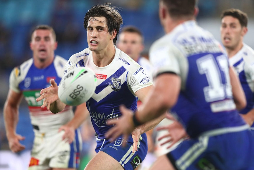 A Canterbury Bulldogs NRL player passes to his left during a match against Newcastle.