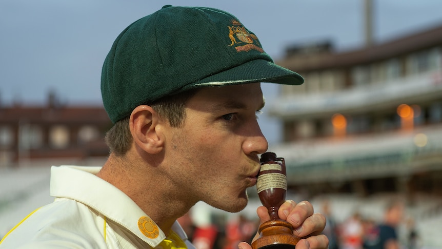 An Australian male cricketer kisses the Ashes urn in 2019.