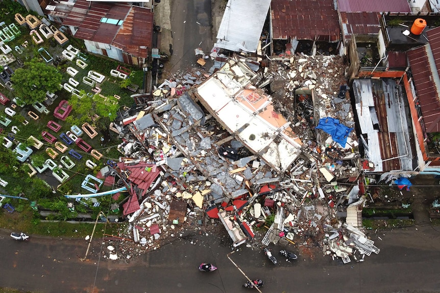 A building is seen badly damaged by the earthquake from the air. Rubble lay strewn on the ground.