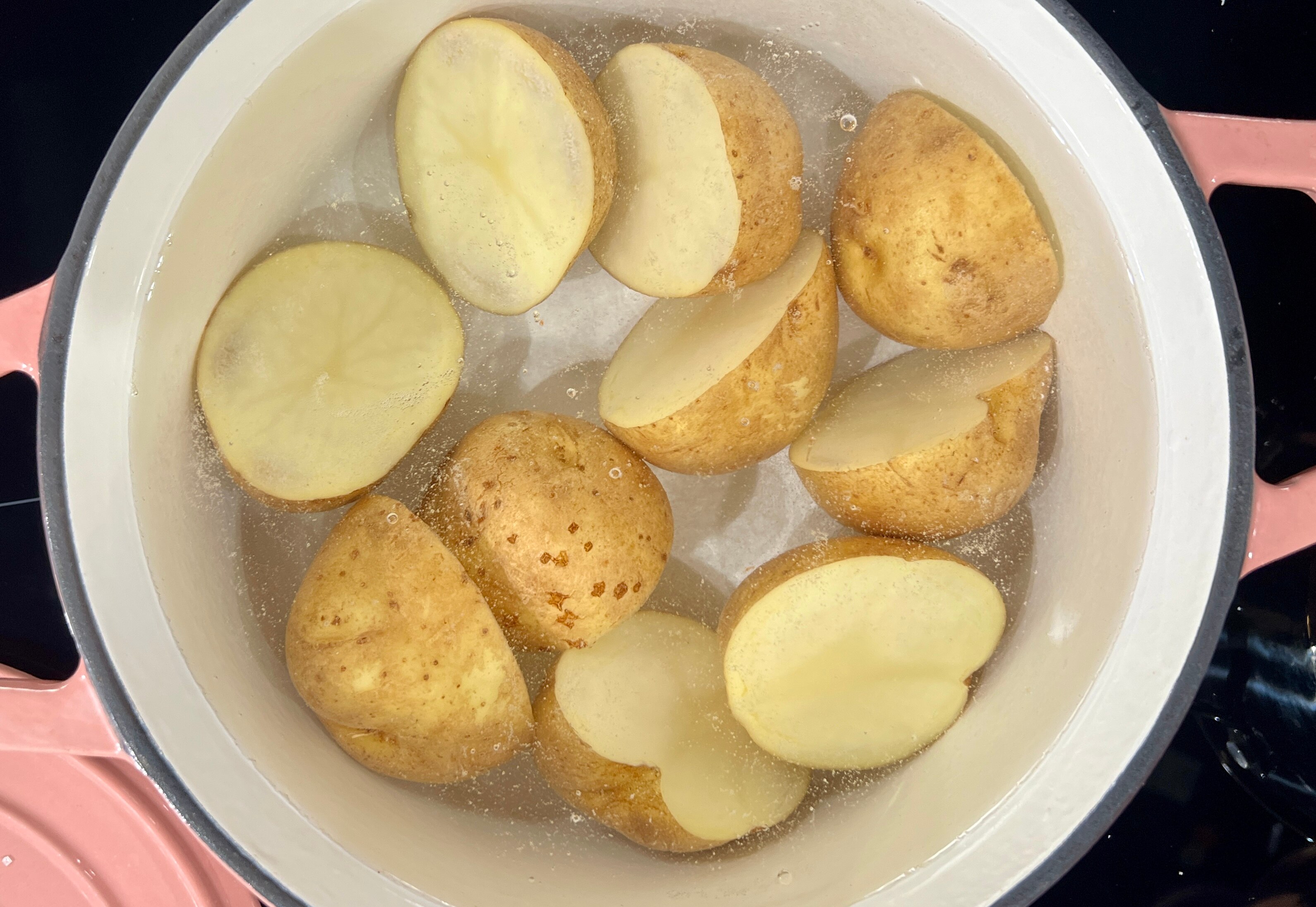 A picture of potatoes in boiling in a pot of water.