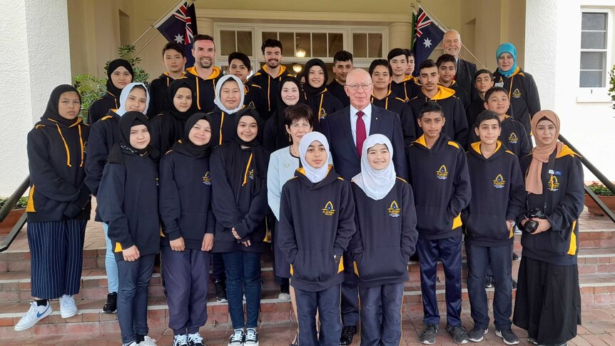 Students pose with David Hurley on the steps of Government House.