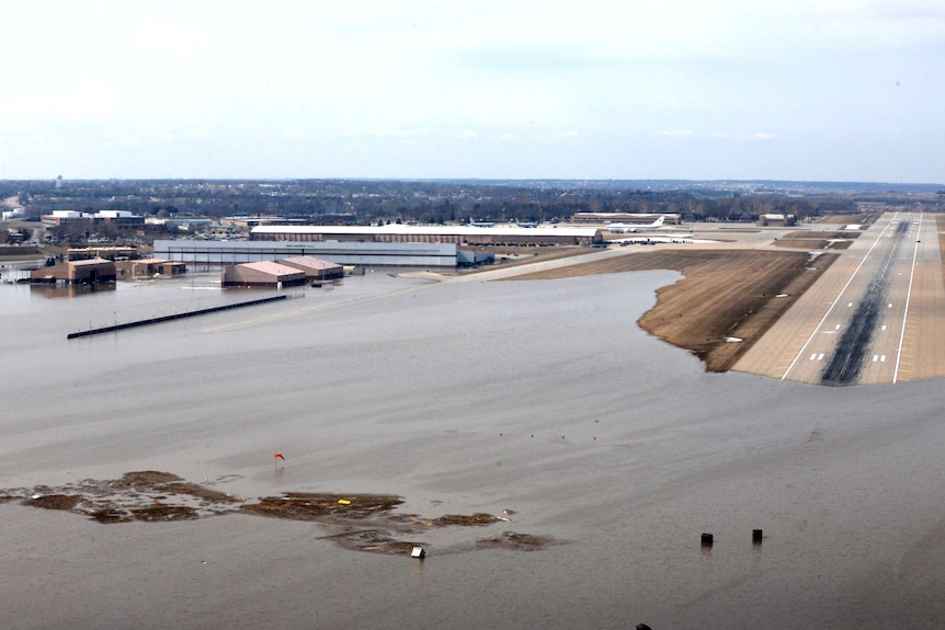 An aerial photo shows a military airport's landing strip partially flooded.