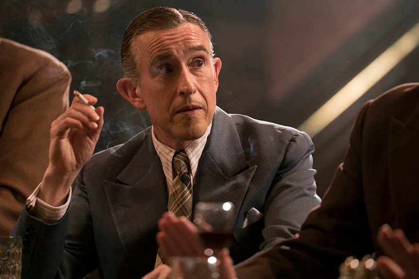 Colour close-up still of close-up of Steve Coogan smoking in 2018 film Stan and Ollie.