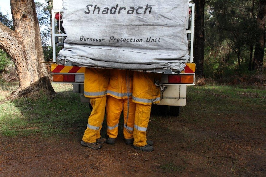 Ocean Beach volunteer firefighter huddles in the fire shield prototype in Denmark, WA.